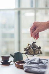 从放着茶水的木桌上提起一串粽子