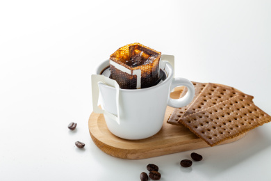 白色桌面上有一杯挂耳咖啡和饼干