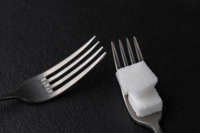 黑色背景中方糖和叉子暗调静物照