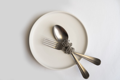 被链条捆绑在盘子中的叉子和勺子微缩创意图