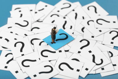 微缩创意一堆问号上看新闻的男性