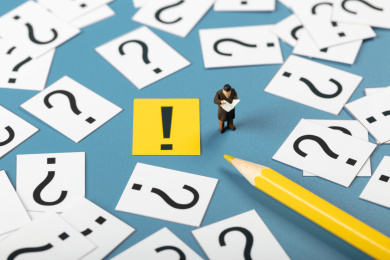 微缩创意问号堆里感叹号旁看新闻的男性