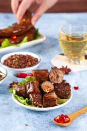 浅底上摆放着酱香鸭脖