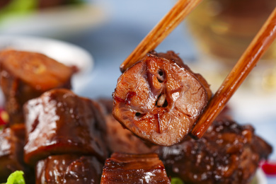 浅底上摆放着酱香鸭脖