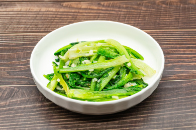 木桌背景一盘蒜蓉炒油麦菜特写