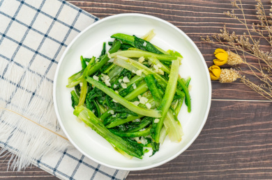 木桌背景一盘蒜蓉炒油麦菜特写