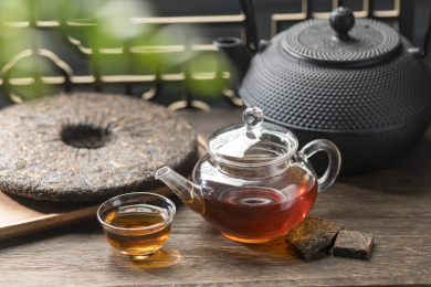 普洱茶与玻璃茶壶茶杯茶水特写木桌面背景