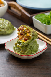 盘子里掰开的绿色五谷杂粮粘豆包