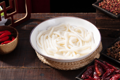 老桌子白盘里的四川重庆火锅菜品土豆粉