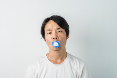 口含安抚奶嘴的白衣成年男子