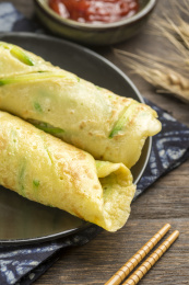 一盘西葫鸡蛋饼摆放在木桌面上