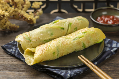 一盘西葫鸡蛋饼摆放在木桌面上