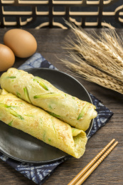 一盘西葫鸡蛋饼摆放在木桌面上