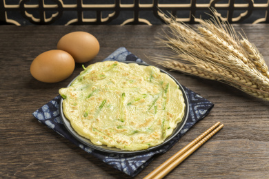 一盘西葫鸡蛋饼摆放在木桌面上