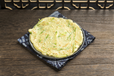 一盘西葫鸡蛋饼摆放在木桌面上