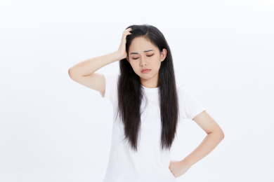 年轻女性手扶额头皱眉难过