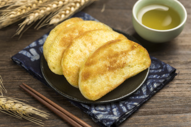 一盘油炸馒头片摆放在木桌面上