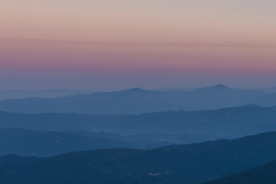 层层叠叠的山峦掩映在黎明的晨雾中