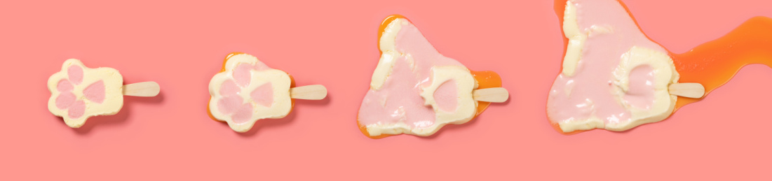 可爱猫爪冰棒在粉红背景的融化过程顶视图