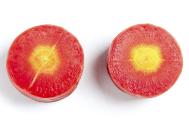 白底上摆放着切段的黄心胡萝卜