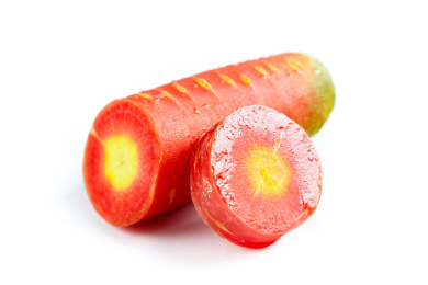 白底上摆放着切段的黄心胡萝卜