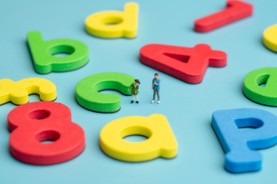 两个站在彩色拼音字母和数字中间的儿童微缩