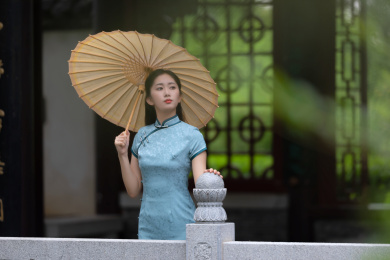 身穿旗袍在庭院里散步的古典美女