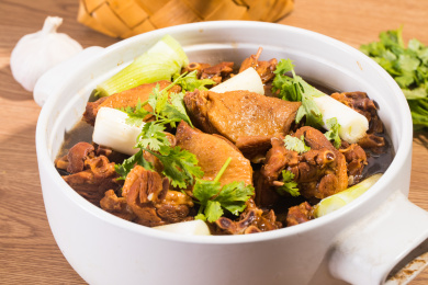 装在白色炖锅里的土豆炖大鹅
