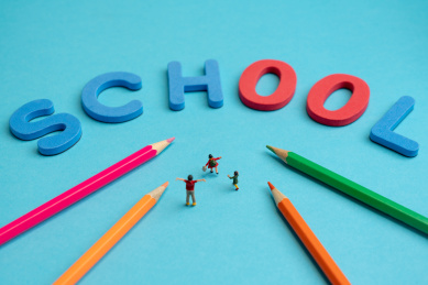 学生高高兴兴的走向字母组成的学校微缩创意