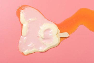 可爱猫爪冰棒融化在粉红的背景