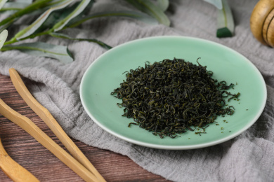 桌面上的盘子里的干爽清香的碧螺春