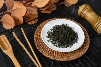 桌面上的盘子里的干爽清香的碧螺春