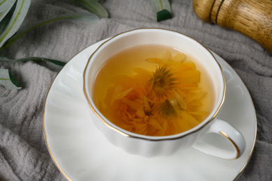 桌面上的杯子里的甘甜可口的金盏菊花茶