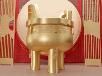 放在大鼓和屏风前面的三足金色大圆鼎