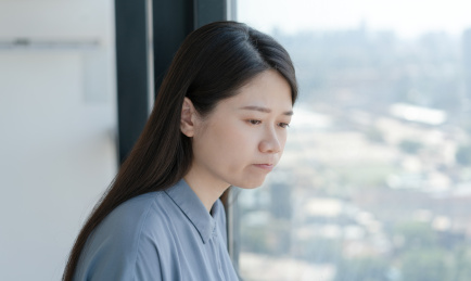 垂头丧气的女人低头挨着窗户