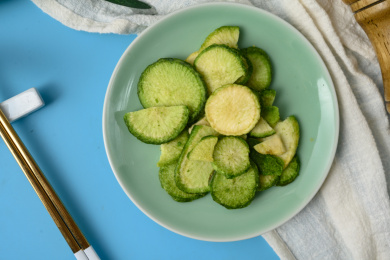 桌面上的盘子里的美味可口的青萝卜脆片