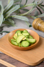 桌面上的盘子里的美味可口的青萝卜脆片