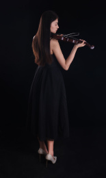 黑色背景里拉小提琴的年轻女性