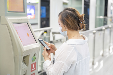 年轻女性正在使用地铁车站内的自助设备