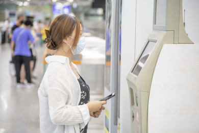 年轻人正在使用地铁车站的自助设备购票