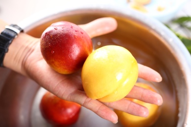 手拿清洗过的新鲜水果油桃