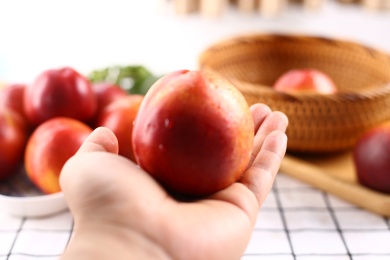 手里拿着一个新鲜水果油桃