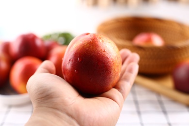 手拿清洗过的新鲜水果油桃