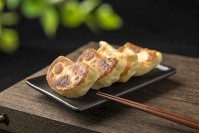 一盘素馅锅贴摆放在木桌面上特写