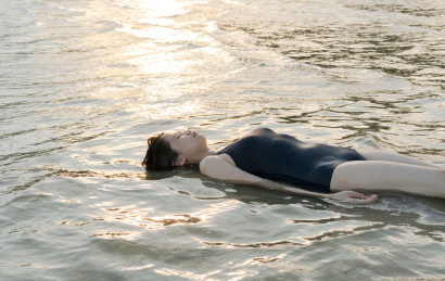 躺在浅滩的海水里睡觉的女人