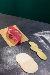 牛肉和饺子皮一起放在黑色桌面上 