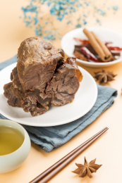 一盘酱牛肉摆放在暖色背景上特写