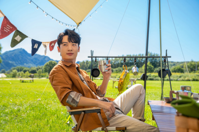 男孩坐天幕下喝咖啡