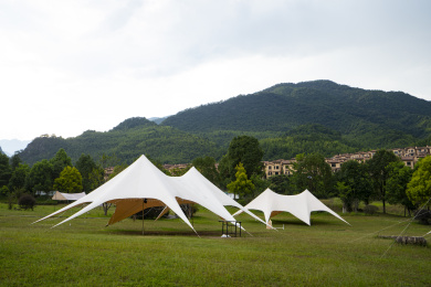 阴沉天气下山区草地上搭建的天幕帐篷