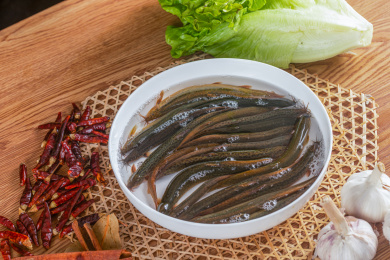 复古背景中装在白瓷碗中的新鲜活泥鳅